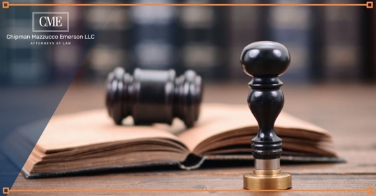 Gavel on a book with a judge's stamp in the forefront