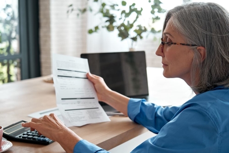 Senior mature business woman holding paper